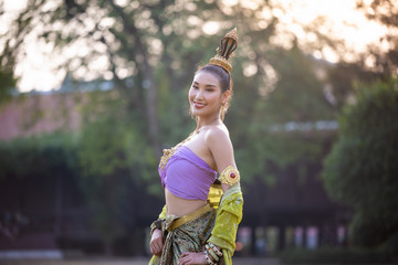 young asian women in traditional dress in the boat and pink lotus flowers iin the pond. Beautiful...