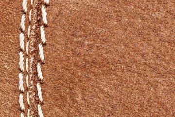 Brown suede empty copy space textile background. White thread sew closeup fabric texture.
