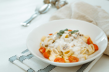 Cooked pasta with a cream sauce and roasted chicken cured with emmental.