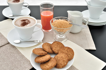 cappuccino biscotti spremuta arancia dall'alto cacao