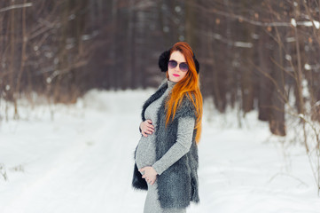 Winter portrait of pregnant woman in forest