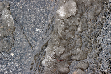 Melting snow asphalt slush water flow puddle dirty street sidewalk
