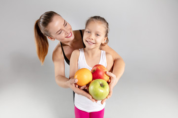Fototapeta premium Beautiful woman and her little daughter with fresh fruits