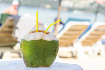 Fresh coconut on a sunny beach background.