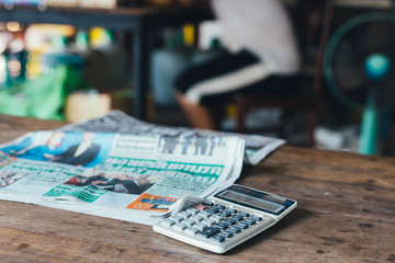 Calculator and thai newspaper in a corner shop