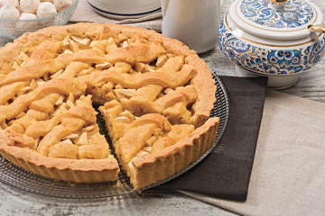 Crostata di mele tagliata con fetta con tazze per il tè e latte orizzontale