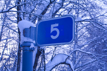 Road sign in winter forest, fifth kilometer