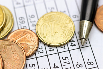 Blank with numbers, pen and money coins.