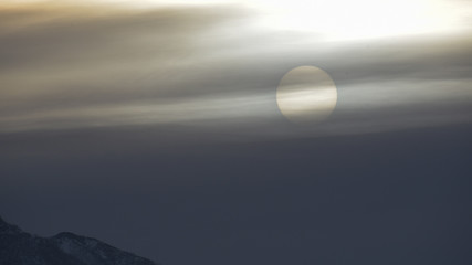 Sole nascosto dietro le nuvole con effetto nebbia