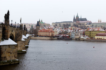 Fototapeta na wymiar Snowy foggy Prague Lesser Town with gothic Castle above River Vltava, Czech republic