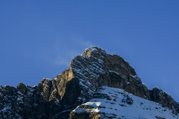 Wind blowing snow over mountain peaks. Corvara in Badia in the Dolomites, South Tyrol, Italy