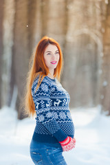 Winter portrait of pregnant woman in forest
