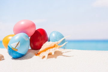 Easter on tropical beach background. Eggs on the white sand. Vacation and travel concept in spring