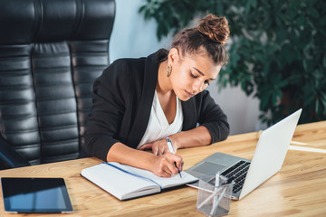 Young business lady dressed in business clothes is in the office.