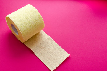 yellow toilet paper roll on pink backgroung