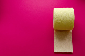 yellow toilet paper roll on pink backgroung