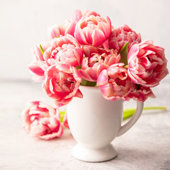 Bouquet of Spring tulips in vase on shabby chic background