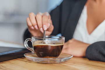 A wooden desktop with a morning black cup of coffee.