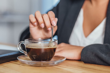 A wooden desktop with a morning black cup of coffee.
