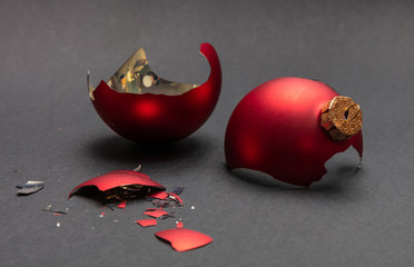 Red Christmas ball broken, dark gray background, closeup view