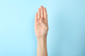 Woman showing B letter on color background, closeup. Sign language
