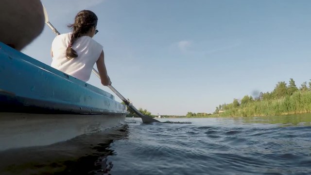 Woman kayaking on the river on a sunny day.