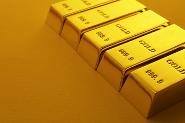 Shiny gold bars on color background. Space for text