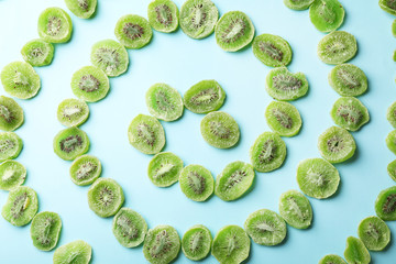 Slices of kiwi on color background, flat lay. Dried fruit as healthy food