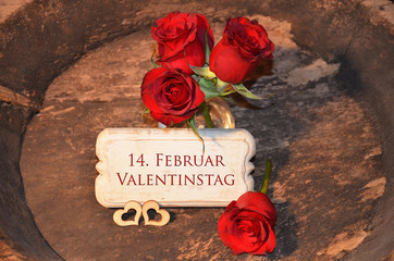 Rote Rosen und Schild mit Schriftzug 14. Februar Valentinstag