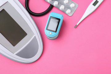 Digital pressure meter and medical objects on color background, top view. Space for text
