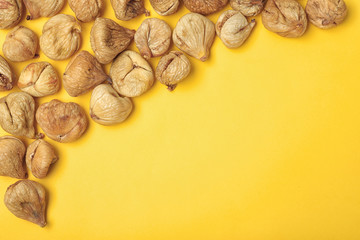 Dried figs on color background, top view with space for text. Healthy fruit