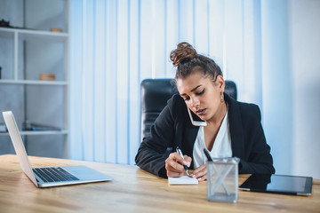 Young girl dressed in business clothes working in the office.