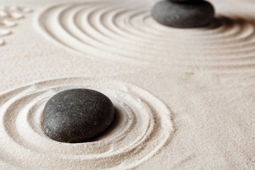 Fototapeta na wymiar Zen garden stones on sand with pattern. Meditation and harmony