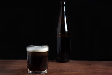 dark beer in a glass on a wooden table