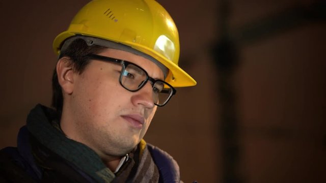 Portrait of architect in yellow helmet with eyeglasess