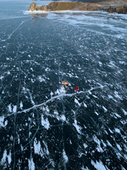 Aerial photo of frozen Baikal lake in winter. Two cars standing on the frozen lake. Beautiful...