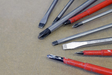 Many screwdrivers on a scratched surface.  Close up image with copy space.
