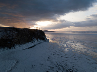 Aerial shot of Olkhon island on sunset in winter. Frozen lake Baikal. Ice and snow. Abraham Lake,...