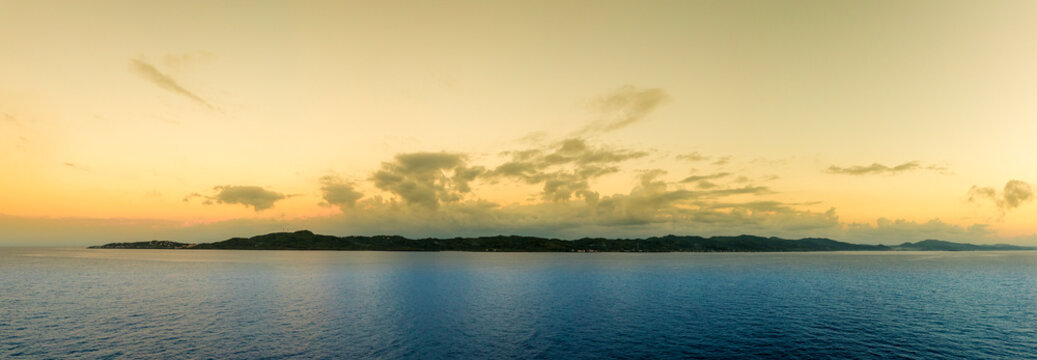 View of Roatan Island at first light, seen from the deck of a ship.