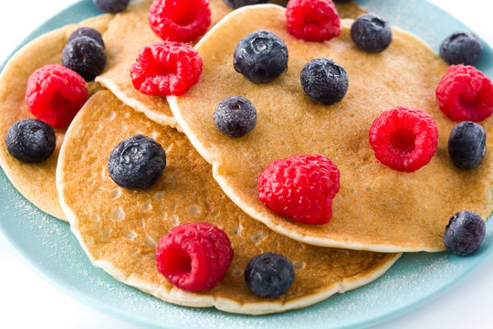 Pancakes with raspberries and blueberries isolated on white background. Close up