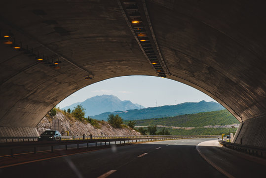 Fototapeta highway tunnel with beautiful view of mountains in the end