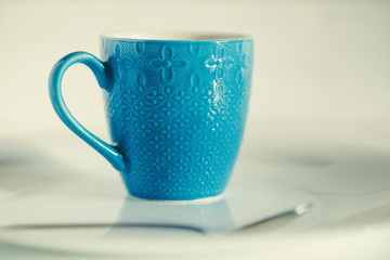 coffee in a blue cup on a light wooden background