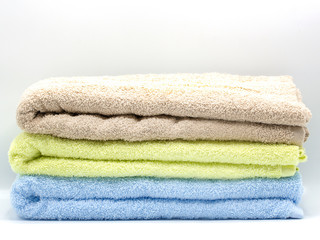 Obraz na płótnie Canvas three color towels isolated on white background
