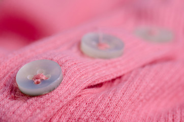 Fabric warm pink sweater buttons textile material texture blur background macro
