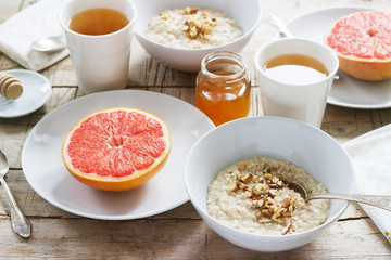 Vegetarian breakfast for two of oatmeal, baked grapefruit and tea. Rustic style.