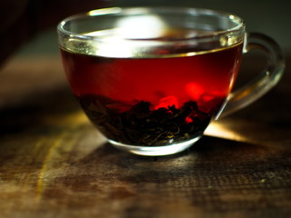 Transparent cup of golden strong tea. Glass cup with tea.