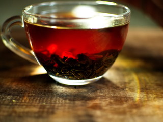 Transparent cup of golden strong tea. Glass cup with tea.