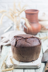 Fresh homemade traditional round rye bread on rustic wooden background