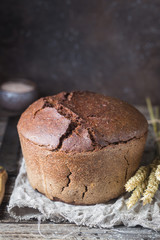 Fresh homemade traditional round rye bread on rustic wooden background