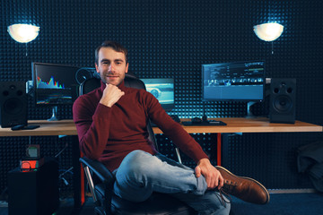 Successful designer or editor sitting leg over leg in a leather armchair